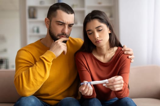 Infertility Problems. Portrait Of Upset Young Couple Looking At Negative Pregnancy Test