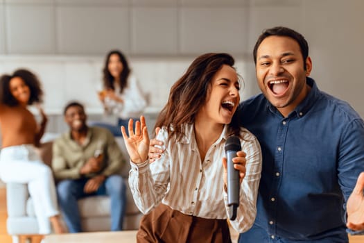 Diverse couple gathers for karaoke session with group friends indoor