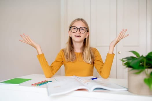 Confused teen girl studying with books at home and raising her hands