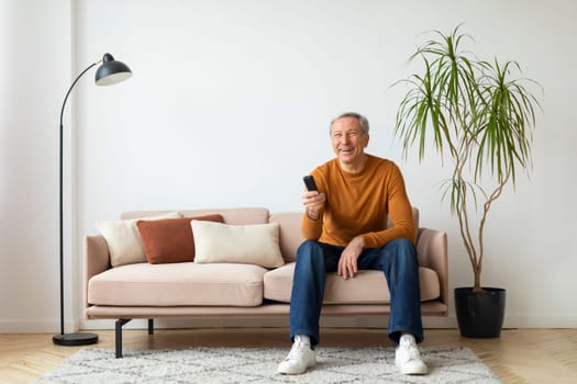 Happy senior man with remote control in his hand