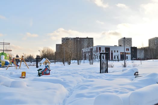Moscow, Russia - Feb 19. 2024. Cityscape with a playground covered in snow