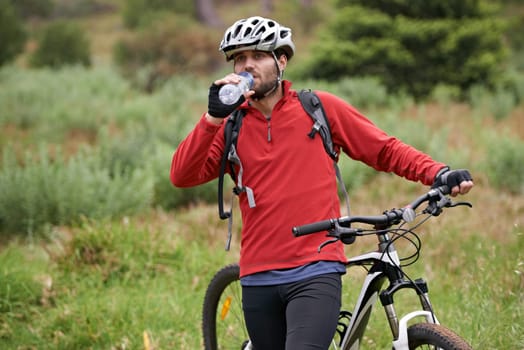 Fitness, bike and man drinking water in countryside for adventure, discovery or off road sports hobby. Exercise, health and wellness with young cyclist on break in nature for training or cycling