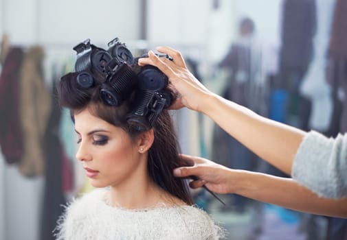 Woman, hair and makeup with curlers and hands of stylist, cosmetic care and beautician with treatment. Beauty in salon, actor or celebrity backstage with hairdresser and haircare for glamour styling