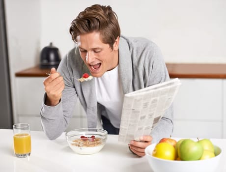 Cereal, juice and man with newspaper in kitchen for information at modern apartment. Nutrition, breakfast and young male person drinking healthy beverage and reading journalism article at home.
