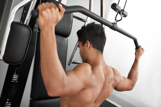 Exercise, pull down machine and man in studio on gray background for training or workout at gym. Fitness, health or shoulder press and body builder with equipment for wellness, strength or power
