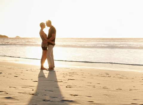 Couple, kiss and beach at sunset for romantic date, weekend getaway and vacation in Mexico. Woman, man or people in love with hug for evening walk, bonding and together in caring happy relationship