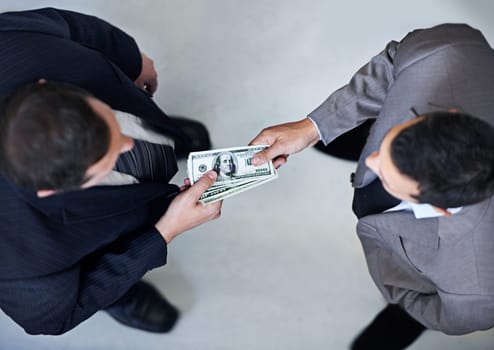 Businessman, money and bribe above with dollar bills for payment, deal or agreement at office. Top view of man, colleagues or employees giving cash, paper or exchange in bribery, scam or fraud
