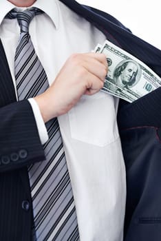 Business person, hands and money bribe in pocket for fraud, scam or secret on a white studio background. Closeup of employee with cash, dollar bills or finance in bribery, deal or financial exchange