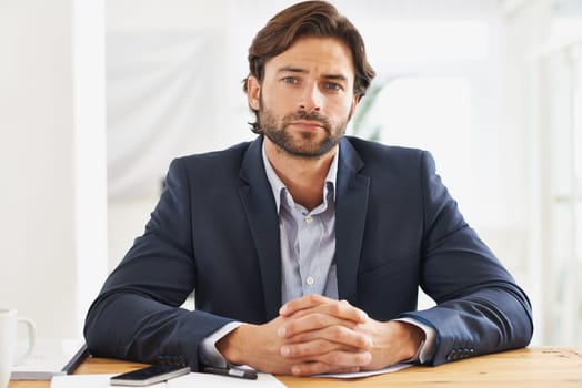 Desk, confidence and portrait of serious businessman with pride, paperwork and serious financial analyst in office. Consultant, business advisor or man with pride, documents and notes at startup.