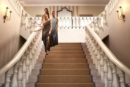 Women, stairs and dress for gala, event and luxury party with confidence and fashion. Friends, classy and elegant group with expensive, fancy and designer clothes with glamour and gown at mansion
