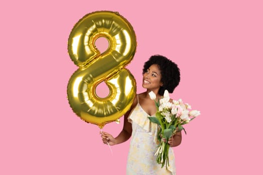 Joyful young woman celebrates her eighth anniversary with a golden number 8 balloon