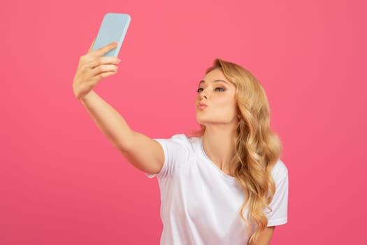 Playful Blonde Lady Making Selfie On Phone Pouting Lips, Studio