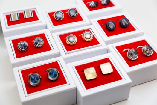 Boxes with cufflinks on shelf in boutique.