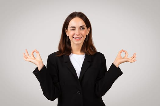 Positive businesswoman with a content smile making the 'okay' sign with both hands