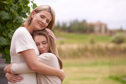 Mother, daughter and hug with love outdoors in nature for mothers day, care and affection for gratitude. Mom, teenage child and bonding together on summer vacation for support, smile and family