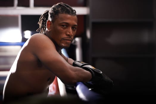 Portrait, fitness and black man boxer in ring at gym for combat sports training or competition. Exercise, boxing or fighting with shirtless young athlete on break from intense self defense workout