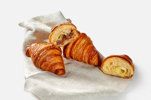 Sweet croissants with nut and chocolate filling on linen cloth