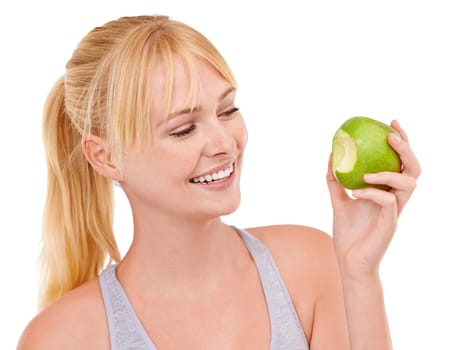 Bite, smile and woman with apple for diet, benefits or food to lose weight in studio. Healthy eating, nutrition and happy face of girl with fruit for body wellness, digestion and white background