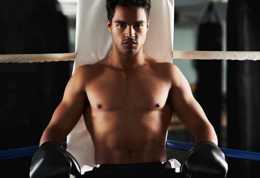 Portrait, man and boxing ring for sports, training and workout at corner of gym for body health. Fighter, serious face and athlete with gloves for fitness, exercise or strong abs at club in Brazil