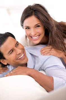 Relax, laugh and portrait of couple on sofa for weekend bonding, playful romance and connection in home. Love, support and trust in marriage, man and woman on couch with embrace, wellness and smile.