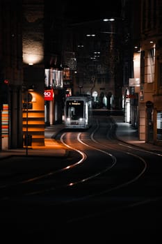 Vertical Photo Photograph of tram in city lights at night with yellow lights
