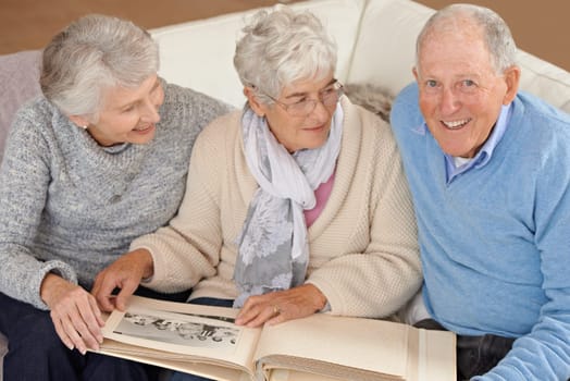 Old people, friends and photo album for memory nostalgia in retirement on sofa together, photograph or connection. Elderly man, women and picture book in home in Canada for bonding, remember or love