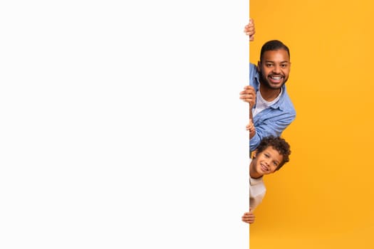 Black Father And Son Peeking Out Of Blank Advertisement Board