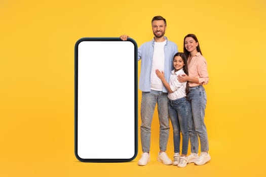 Parents and daughter leaning on phone mockup on yellow backdrop