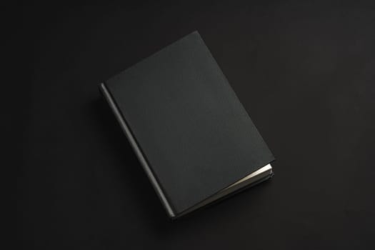 Black hardcover book or notepad mock up on black background