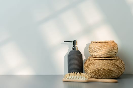 Soap dispenser and hair brush on gray background