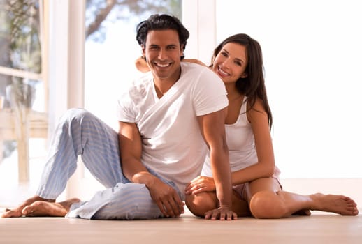 Mexican couple, portrait and bonding and smiling, indoor and sunset for home in living room. Husband, wife and embrace for love, confident and new house on wooden floor for marriage and happiness