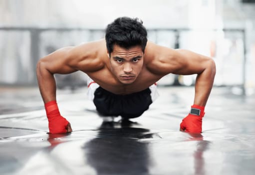 Fighter, portrait and push ups for sports in gym for training, wellness and workout for body. Man, exercise and gloves on fists, muscle and health for person in fitness centre, strong and serious