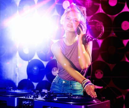 Portrait, woman dj and headphones for retro, nightclub and party with neon lights and lens flare. Happy gen z person, listen and mixing tracks and vinyl at rave or techno music event in Berlin disco