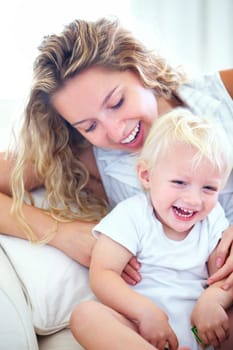 Mother, toddler and together with love on couch for bonding, learning and relax with safety for kid. Single mom, child and playful with laughter for growth, development and happy in home on sofa