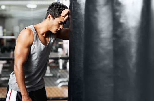 Gym, fitness and tired with man and punching bag, low energy and performance mistake or disaster. Sports, fatigue or boxer exhausted by intense body workout, challenge or fighting practice burnout