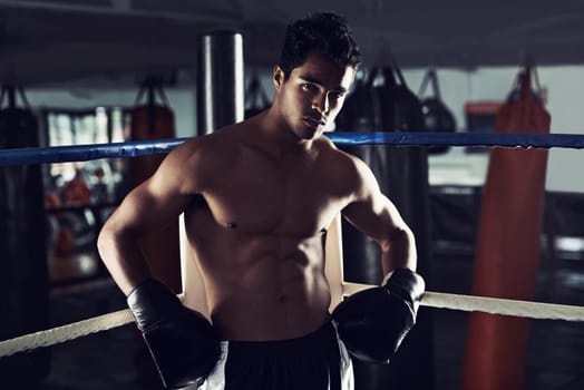 Male person, boxing and sport in gym, portrait and fitness for exercise and wellness in training for strong fight. Man, athlete and boxer in workout, challenge and shirtless ready to punch for mma