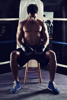 Workout, man and boxing ring for sports, corner or training for competition in gym for body health. Fighter, strong athlete and serious person with gloves for fitness, exercise and muscle at club