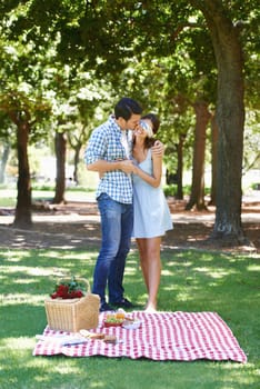 Date, picnic and surprise with couple in park for romance, bonding and summer vacation. Happiness, commitment and relax with man and woman in love in nature for blindfold, support and relationship