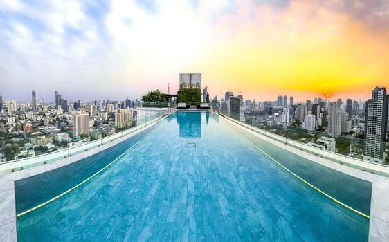 Rooftop pool with Bangkok skyline view at sunset, in Bangkok Thailand