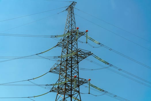 High voltage towers with sky background. Power line support with wires for electricity transmission. High voltage grid tower with wire cable at distribution station. Energy industry, energy saving