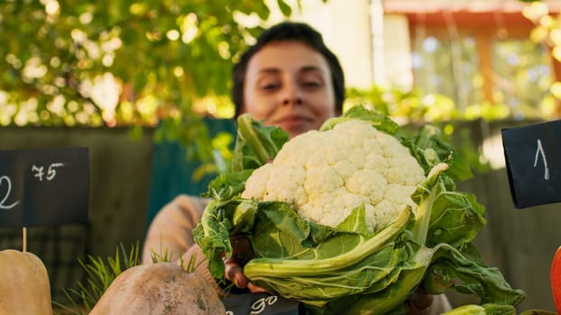 Woman farmer presenting cauliflower for healthy nutrition