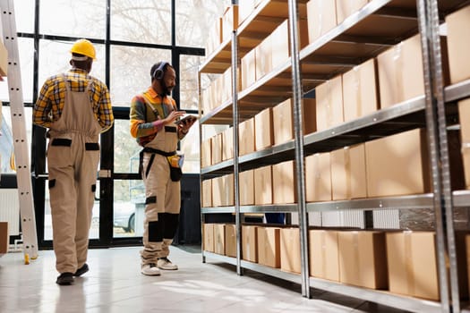 Warehouse employee in headphones overseeing parcels security and maintenance