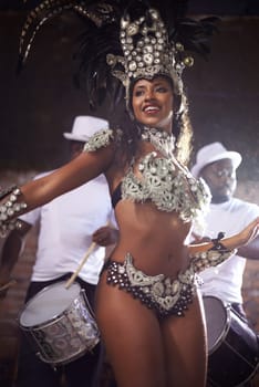Carnival, woman is dancing in street and performance in Brazil, costume and feather head gear outdoor. Music, samba dance and happiness for event, culture with festival entertainment and talent