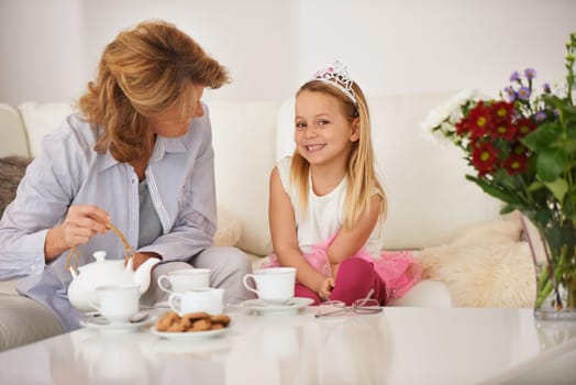 Mom, daughter and happy for tea party in living room with bonding, playing and breakfast or brunch at home. Mother, family and girl or child in portrait with teapot, biscuits and princess for fun