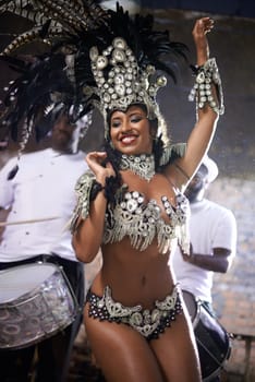 Carnival, dance and woman for performance in Brazil, dancer with gemstone outfit and feather head gear outdoor. Music, samba and happiness for event and culture with festival entertainment and talent