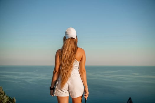 Portrait of a happy woman in a cap with long hair against the sea