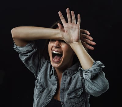 Hands, stress and horror with woman screaming in studio on black background for reaction to fear. Crazy, anxiety and mental health with young person screaming in dark for drama, nightmare or terror