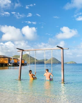 Couple in a swing on the beach of the tropical Island Saint Lucia or St Lucia Caribbean