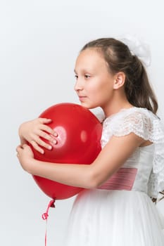 Portrait of girl hugging red balloon with both hands, put chin on ball, looking to side on white