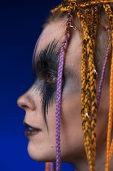 Fine art portrait of woman with horror black stage make-up painted on face and dreadlocks hairstyle